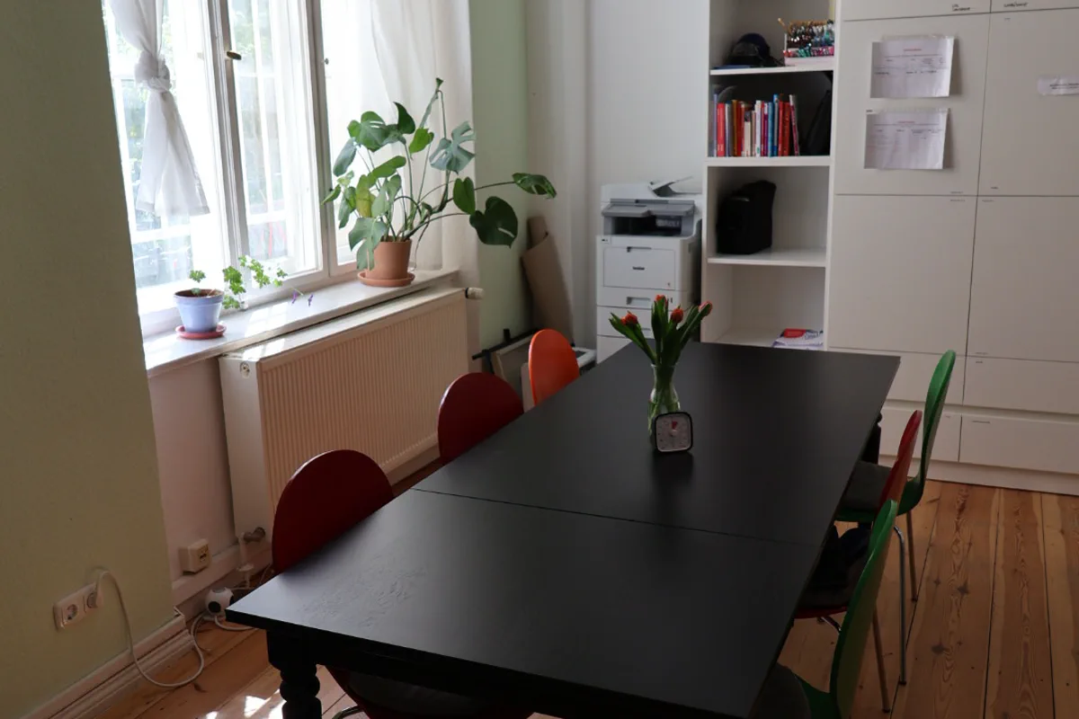 Besprechungsraum mit großem Tisch und Pflanzen